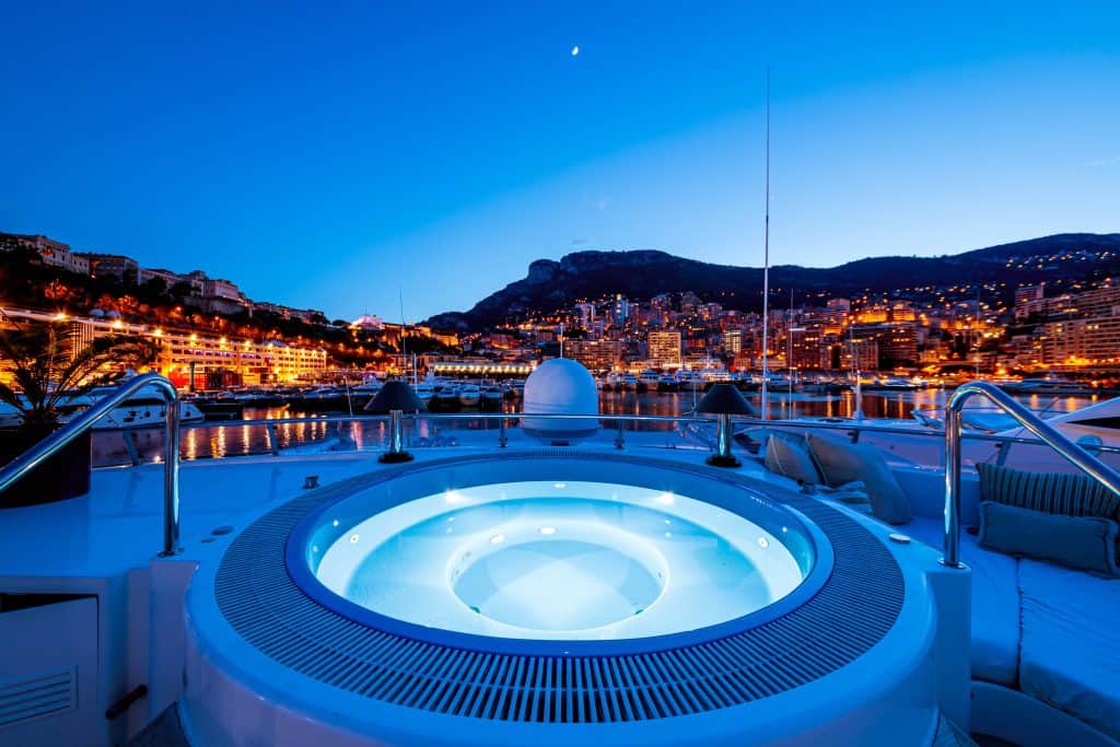 Monaco Port Hercules marina with luxury apartments and superyachts, showing the premium lifestyle available to residents